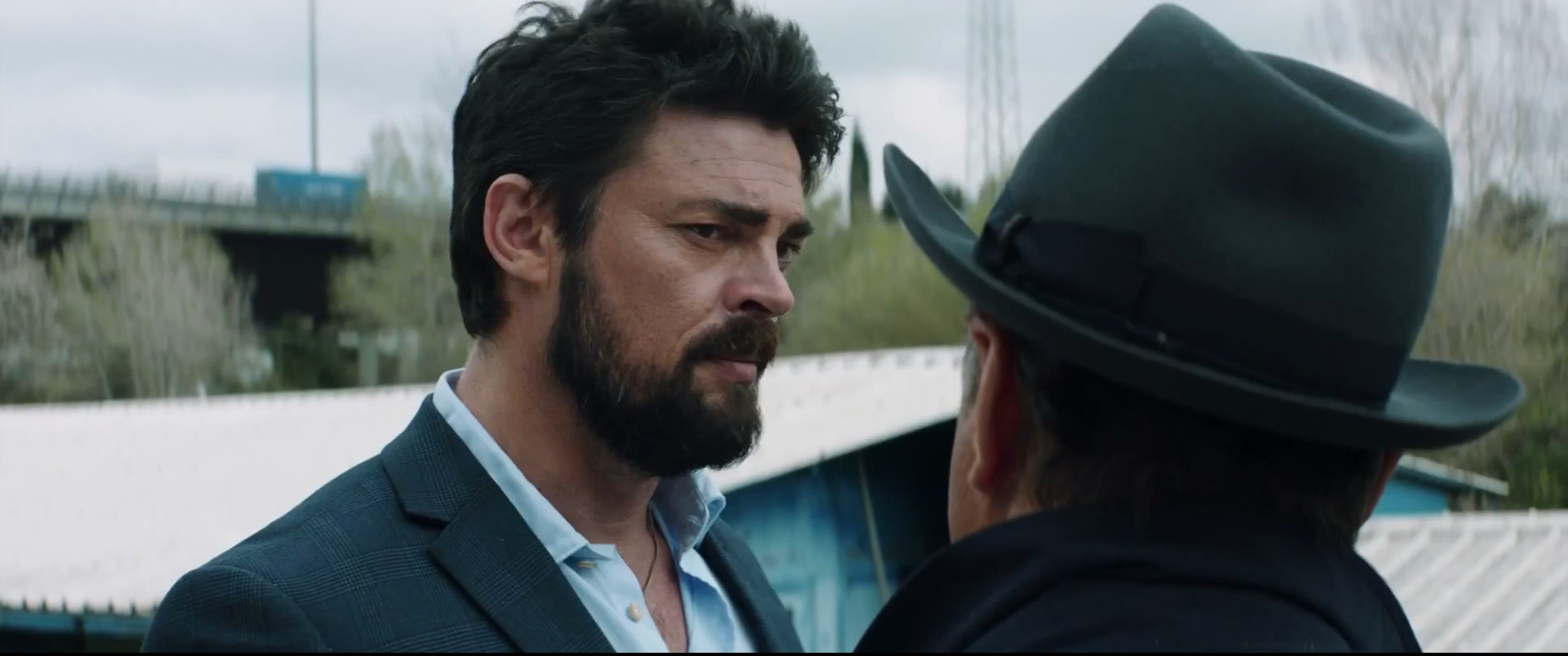 Karl Urban di fronte a un uomo con cappello