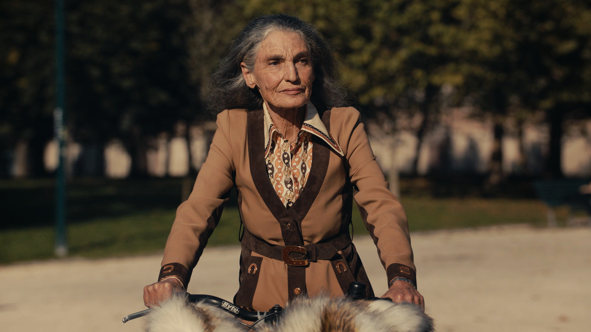 Donna anziana in bicicletta in un parco