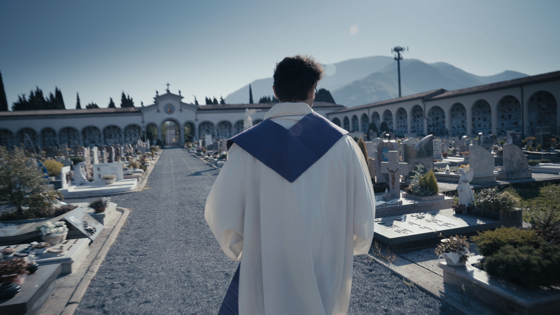 Sacerdote di spalle nel cimitero